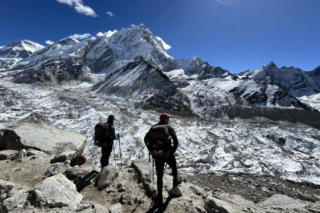 Hikers standing in front of glacier and mountains near the Everest Base Camp