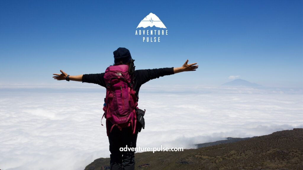 Trekker standing on a cliff and above the clouds on Kilimanjaro Trek.