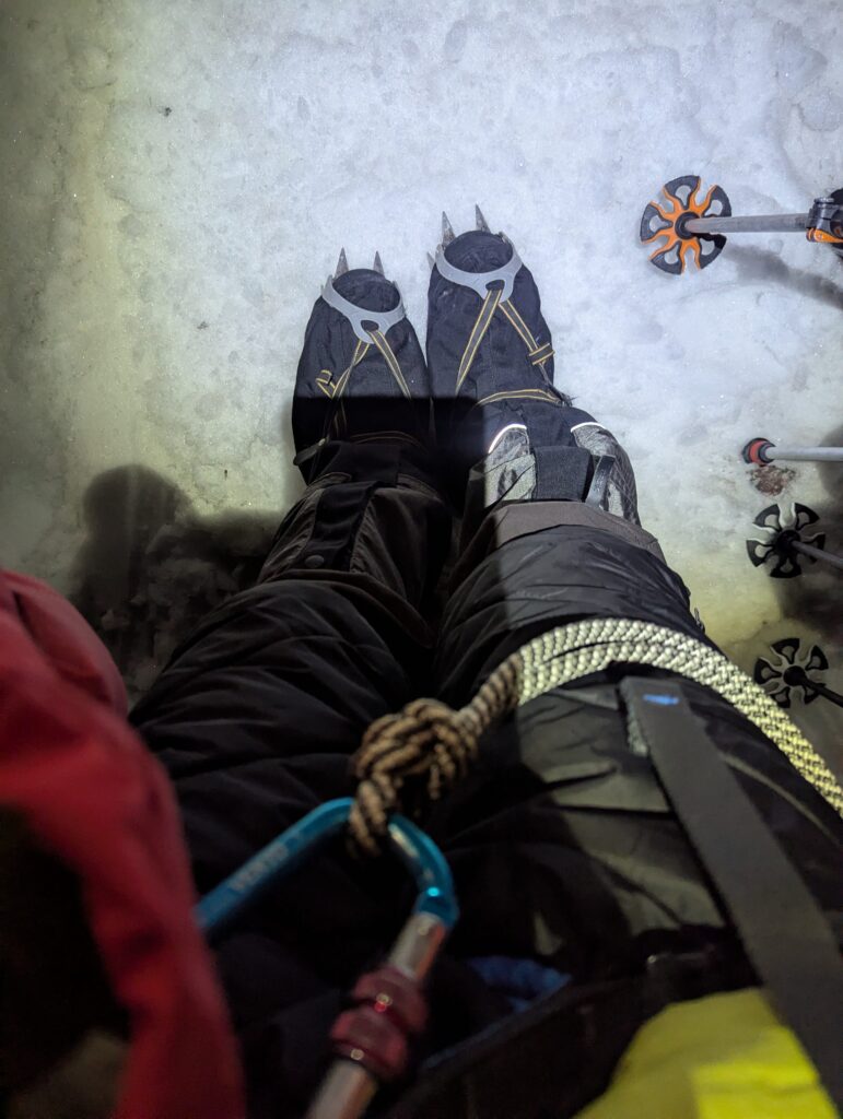 Headlamps illuminate the snow and ice in the middle of the night